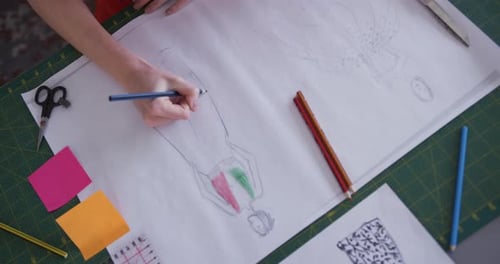 Caucasian woman drawing in fashion office