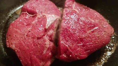 Raw Meat Sizzling and Cooking in Pan
