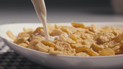 Pouring Milk on Crunchy Corn Flakes Cereal