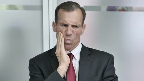 Man in Suit Expressing Tooth Pain
