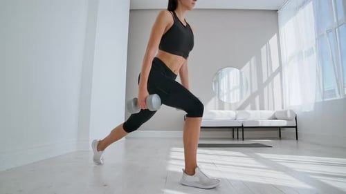 Young Fit and Energetic Woman Doing Sport Workout and Fitness Lunge Exercises with Weights for