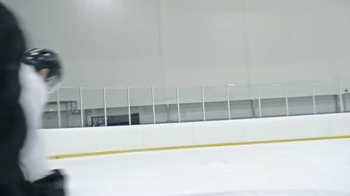Hockey Players Fighting for Puck and Falling on Ice