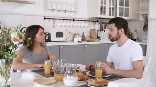 Couple Enjoying Breakfast Together at Kitchen Table