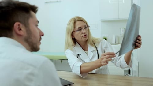 Doctor Explains X-Ray to Patient in Modern Office