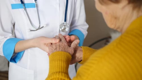 Doctor Gently Holds Senior Woman's Hands