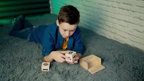 Boy Arranges Wooden Perpetual Calendar on Grey Rug