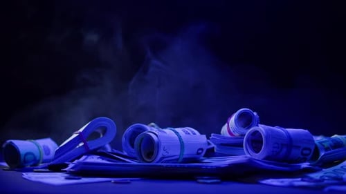 Money Rolls and Bank Notes in Blue Light