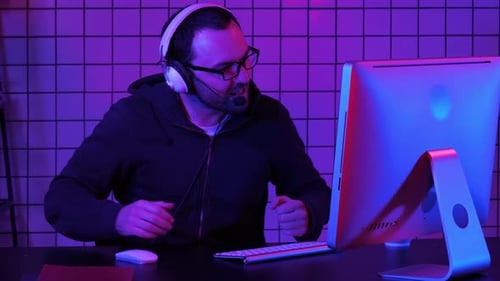 Enthusiastic Young Adult Gaming on Computer at Night