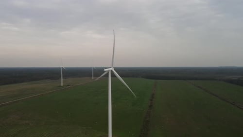 Wind Turbines Rotating in a Green Field, Aerial View