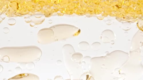 Golden Liquid Pouring into Water: Abstract Macro Shot