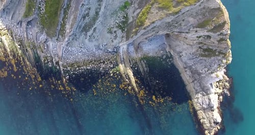 Aerial View of Rocky Coastline Meeting the Ocean