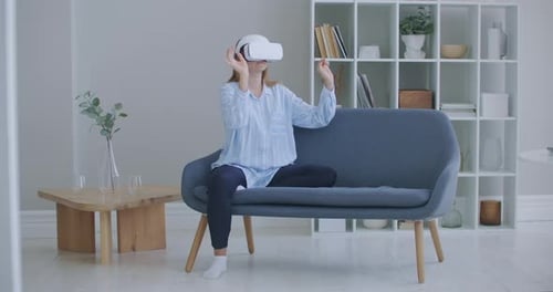 Woman Using VR Headset Sitting on Couch