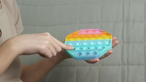 Girl Popping Pastel Toy Bubbles for Sensory Play