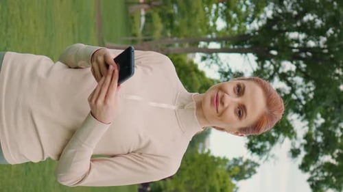 Smiling Woman with Phone in the Park