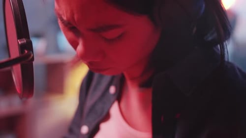Close Up of Asian Female Singer Playing Guitar and Singing in Home Studio