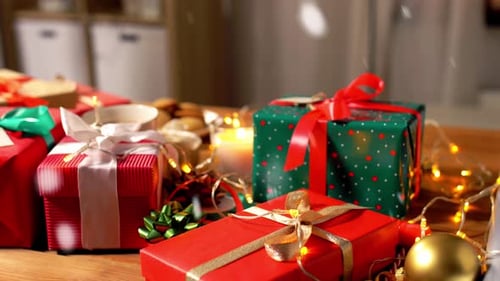 Festive Wrapped Christmas Presents with Candlelight and Snow