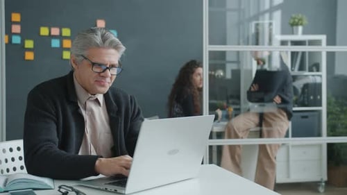 Man Working on Laptop in Bright Modern Office