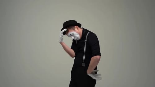 Portrait d'un mime masculin joyeux et réfléchi réfléchit à se gratter la tête en se touchant la main au menton