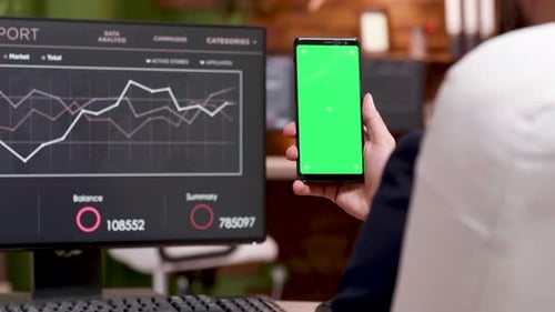 Back View of Caucasian Businessman Holding Mobile Phone with Green Screen