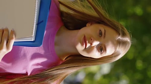 Vertical Screen Student in Park with Books in Hands