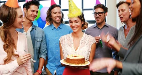 Enthusiastic Colleagues Celebrate Birthday with Cake and Blowers