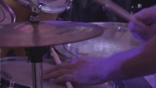 Drummer Plays Percussion Instruments at a Concert As Part of a Musical Group