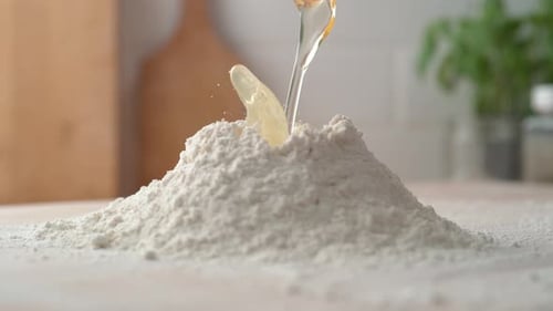 Egg Cracking into Flour Pile for Baking
