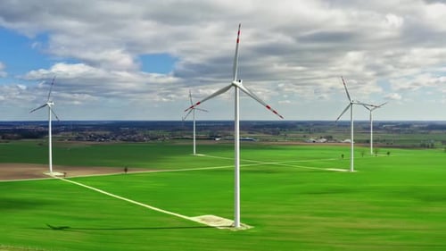Wind turbines with blue sky on green field, aerial view, Poland