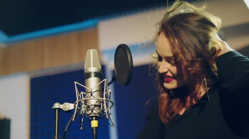 Woman singing in a recording studio. Female vocals. Professional recording studio.