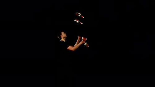 Man Juggling Bottles in the Dark