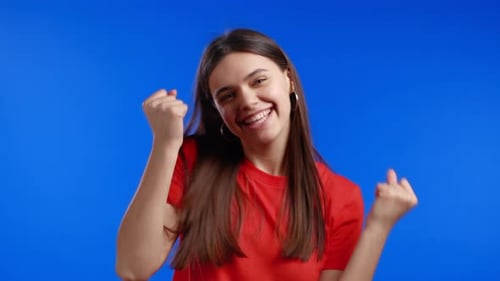 Enthusiastic Woman Celebrating Success on Blue Background