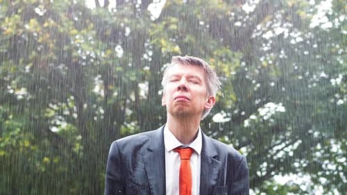 Adult Man in Suit Stands in Heavy Rain