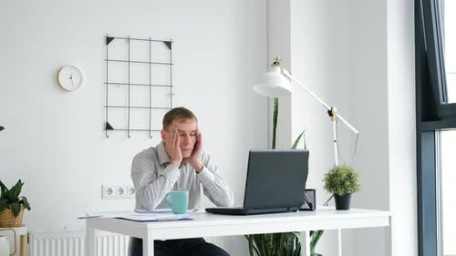 Young Man Working on Laptop in Office
