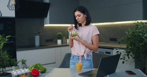 Woman Enjoys Healthy Salad in Modern Kitchen