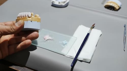 Dental Technician Repairing a Set of False Teeth
