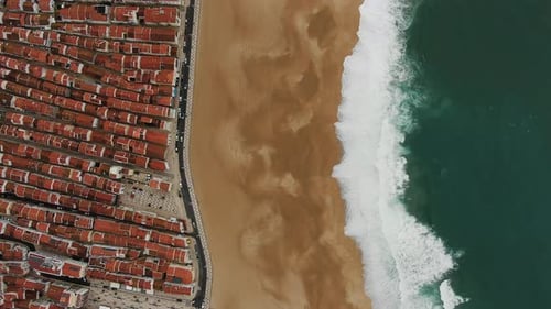 Upper View of Ocean Waves Approaching Yellow Beach Near Town