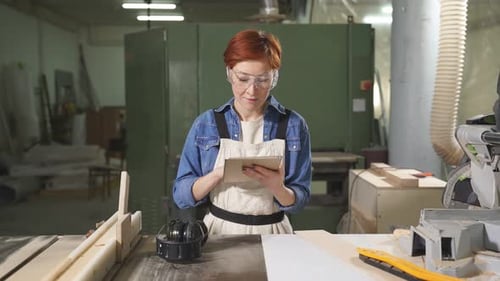 Woman Uses Tablet in Bright Workshop