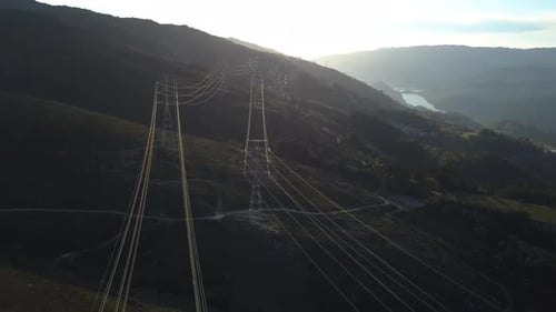 Powerlines and Towers in a Mountain Landscape at Sunrise