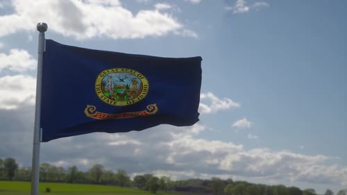 Idaho State Flag Waving with Natural Sky Background