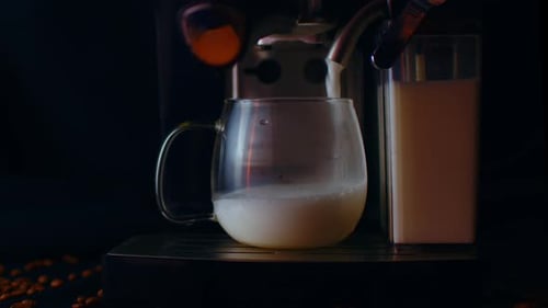 Frothy Milk Poured from Coffee Machine into Mug