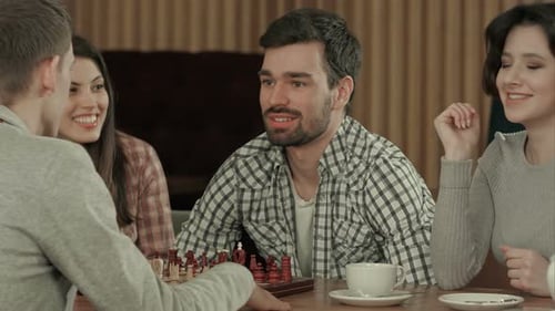 Gruppe von Schülern spielt Schach im Café
