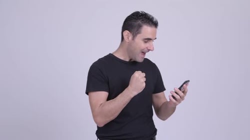 Man Celebrating Success on Mobile Phone
