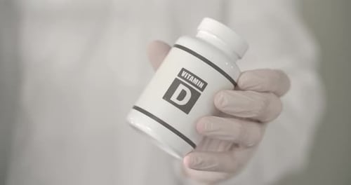 Vitamin D Pills in Gloved Hand