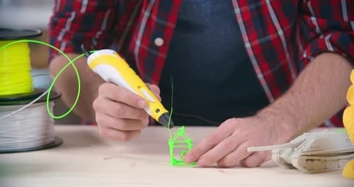 Adult Hands Crafting House with a 3D Printing Pen