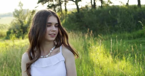 Smiling Young Woman in a Sunny Meadow