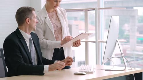 Two Business People Talk Project Strategy at Office