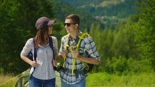 Couple Smiles While Camping in a Mountain Forest
