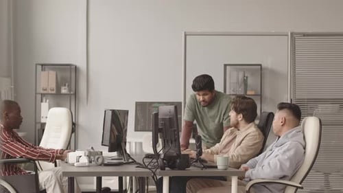 Équipe multiethnique de développeurs de jeux vidéo travaillant au bureau