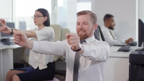 Office Workers Stretching on Exercise Balls at Desks