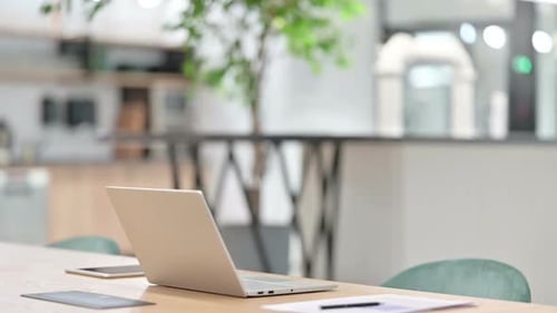 Woman Sits at Desk and Opens Laptop